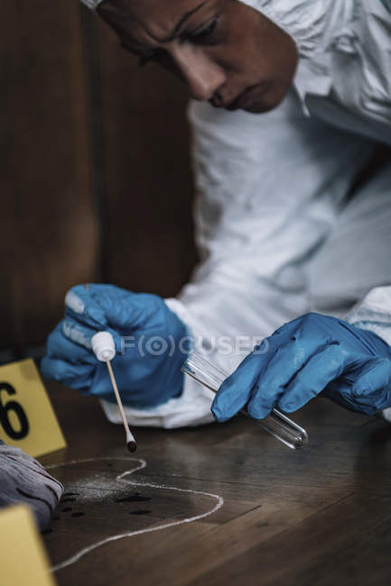 Experto forense recogiendo muestras de sangre de la escena del crimen . - foto de stock