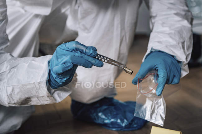 Forensics expert collecting evidence bullet from crime scene. — Stock Photo
