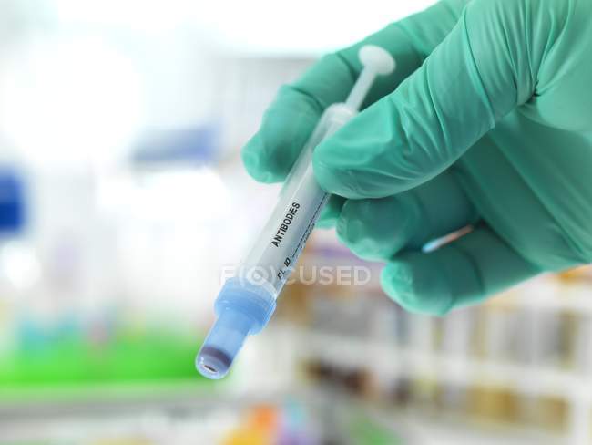 Close-up of doctor holding prepared antibodies syringe. — Stock Photo