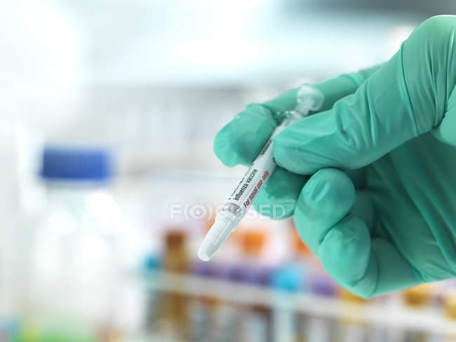 Крупный план проведения врачом подготовленной вакцины против гриппа
. — стоковое фото