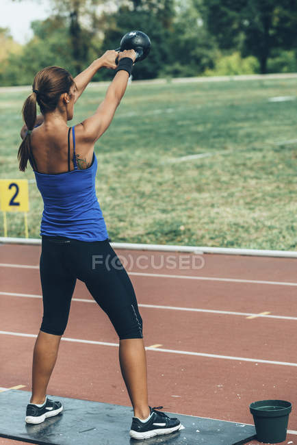 Жінка-спортсменка бере участь у змаганнях з гойдалки чайників . — стокове фото