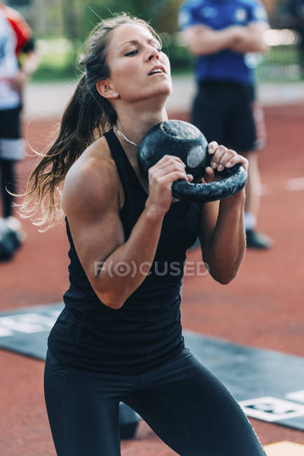 Donna che fa altalena campana bollitore allo stadio di atletica . — Foto stock