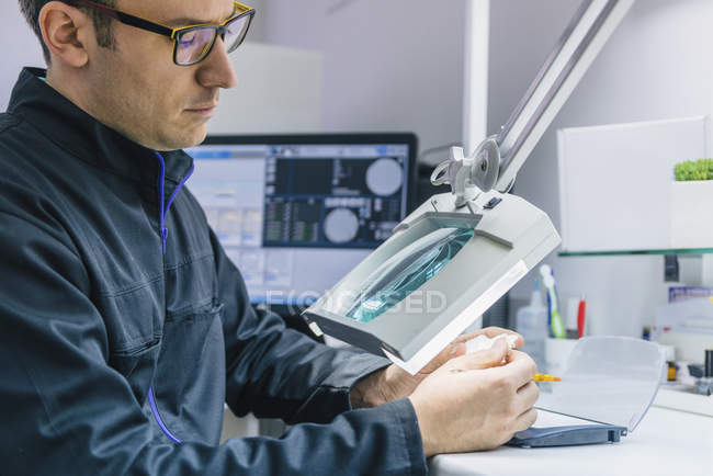 Mid adult male prosthetic dentistry technician at work. — Stock Photo
