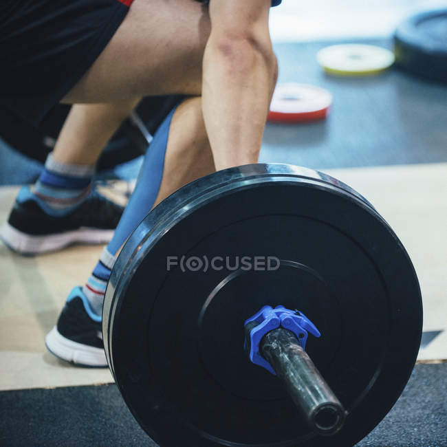 Sección baja del entrenamiento de levantamiento de pesas masculino en el gimnasio
. — Stock Photo