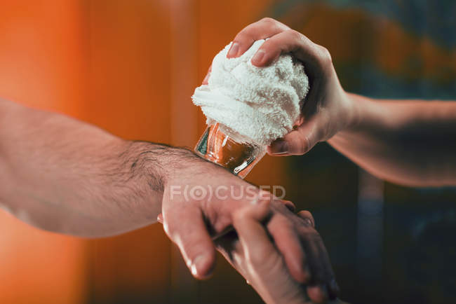 Close-up of female physiotherapist performing cryo massage for wrist pain. — Stock Photo