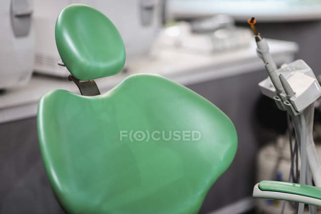 Primo piano della sedia verde vuota del dentista nella clinica medica . — Foto stock
