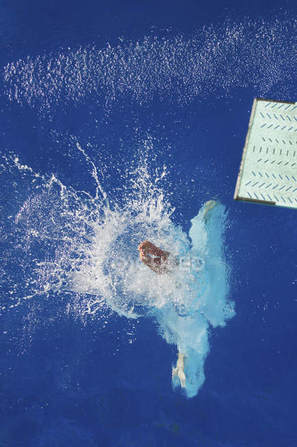 Vista de ángulo alto del buzo que entra en el agua de la piscina
. - foto de stock
