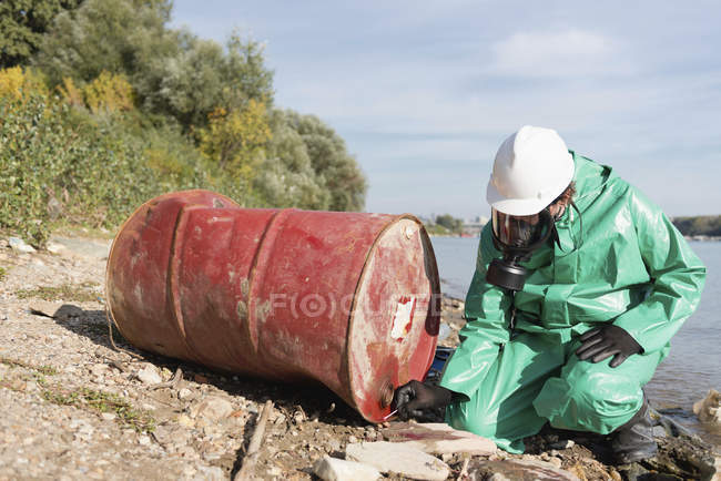Inspecteur de lutte contre la pollution travaillant et examinant le baril rejeté . — Photo de stock