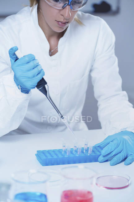 Female science researcher using micropipette in laboratory. — Stock Photo