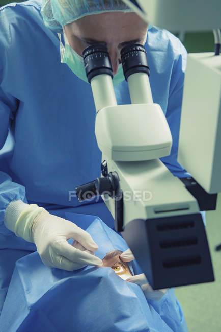 Ophthalmologist performing eye surgery on female patient in clinic. — Stock Photo
