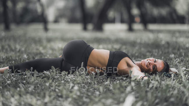 Sportliche Frau dehnt sich nach Übung im Park. — Stockfoto
