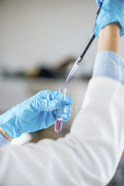 Technicien de laboratoire avec prélèvement de micro pipettes dans une éprouvette
. — Photo de stock