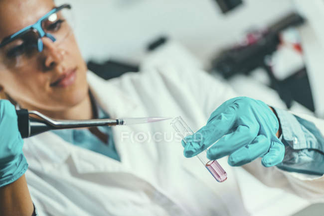 Técnico de laboratório com amostragem de micropipetas no tubo de ensaio . — Fotografia de Stock