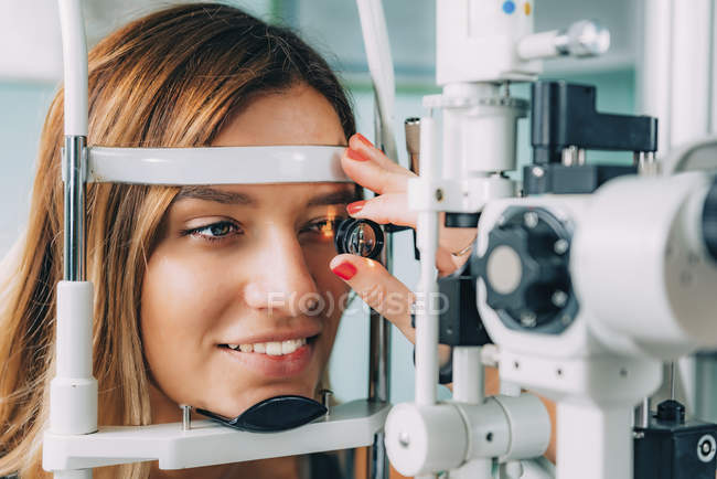 Augenarzt untersucht Patientin mit Spaltlampe und Lupe. — Stockfoto