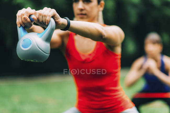 Donne che si allenano all'aperto con kettlebell ed elastico
. — Foto stock