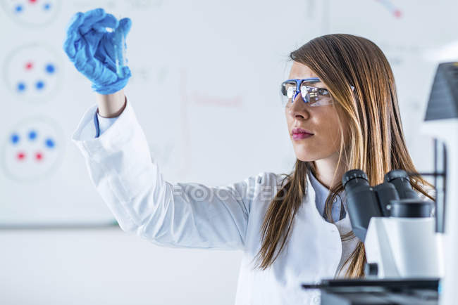 Pesquisador científico de laboratório usando tubo de ensaio durante a experiência . — Fotografia de Stock