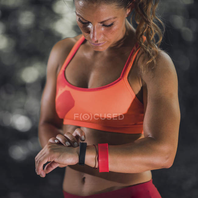 Sportlerin nutzt Fitnessband, um Aktivitäten im Freien zu verfolgen. — Stockfoto