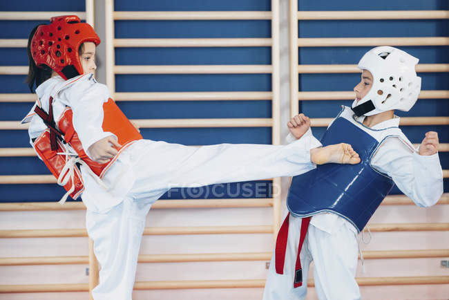 Los niños que luchan en clase taekwondo . - foto de stock