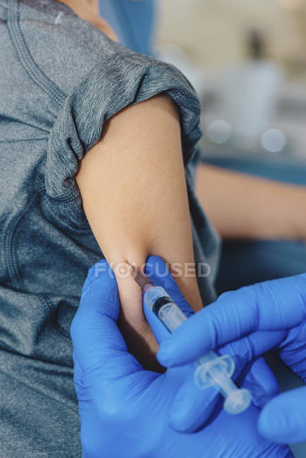 Doctor making syringe vaccination to preschooler boy in medical clinic. — Stock Photo