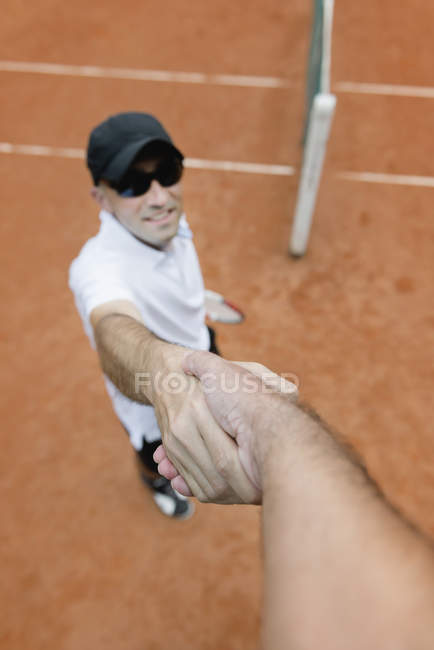Giocatore di tennis stringendo la mano con arbitro dopo partita . — Foto stock