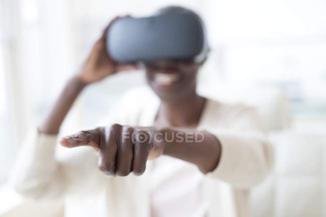 Mulher madura vestindo fone de ouvido realidade virtual e apontando . — Fotografia de Stock