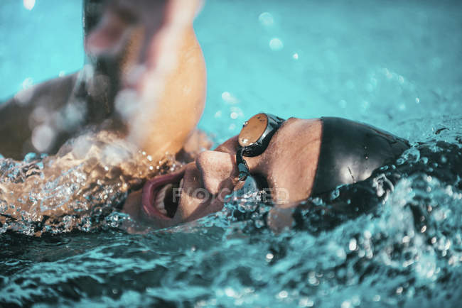 Woman swimming in freestyle front crawl style in swimming pool. — Stock Photo