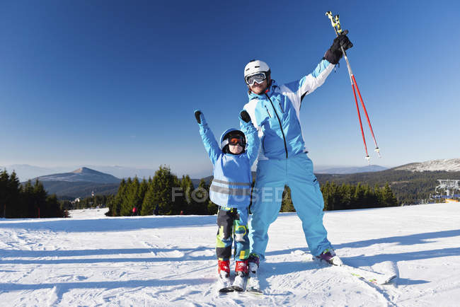 Веселые отец и сын позируют с лыжами на лыжном склоне
. — стоковое фото