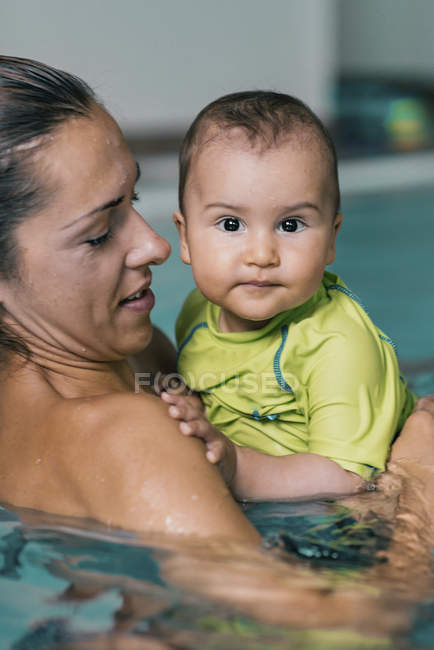 Madre con el niño en la piscina . - foto de stock