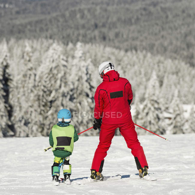 Scuola materna ragazzo sci con istruttore maschio . — Foto stock
