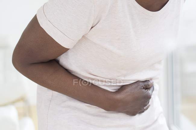 Sección media de la mujer madura con dolor de estómago
. - foto de stock
