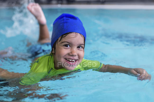 Lächelnder kleiner Junge lernt Schwimmen im Schwimmbad. — Stockfoto