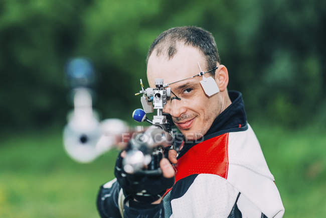 Hombre adulto practicando tiro con rifle deportivo . - foto de stock