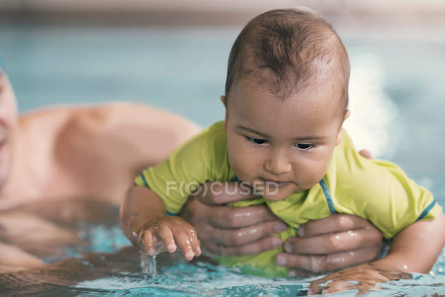 Bambino che nuota in acqua della piscina pubblica . — Foto stock