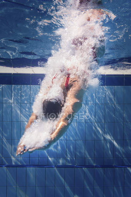 Жіночий плавець занурюється у воду громадського басейну . — стокове фото