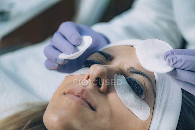 Cosmetologist que põe a pintura preta em pestanas durante o procedimento de levantamento e laminação de pestanas . — Fotografia de Stock