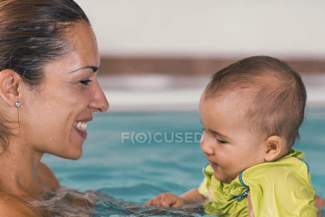 Mère avec bébé garçon mignon dans la piscine . — Photo de stock