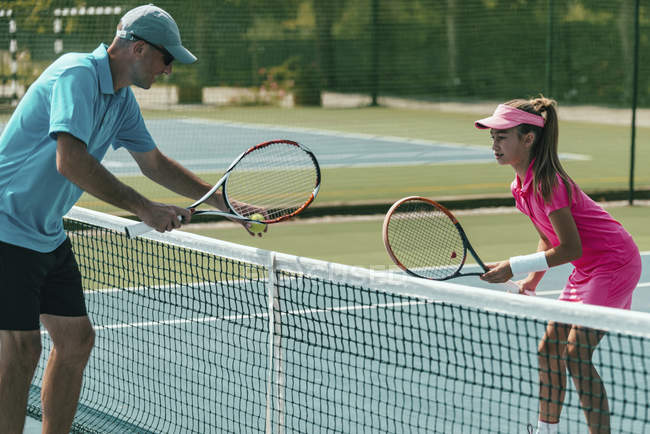Tennislehrer trainiert Teenager-Mädchen auf Tennisplatz. — Stockfoto