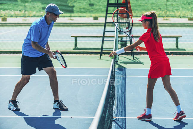 Adolescent fille dans tennis formation sur court avec mâle instructeur . — Photo de stock