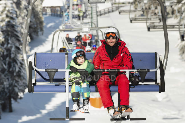Pai e filho montando no teleférico no resort de inverno . — Fotografia de Stock