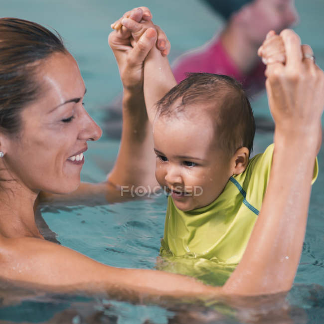 Bambino e madre in piscina . — Foto stock