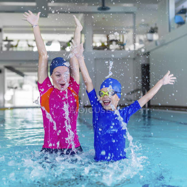 Cute little boy having fun with swimming instructor in swimming pool. — Stock Photo