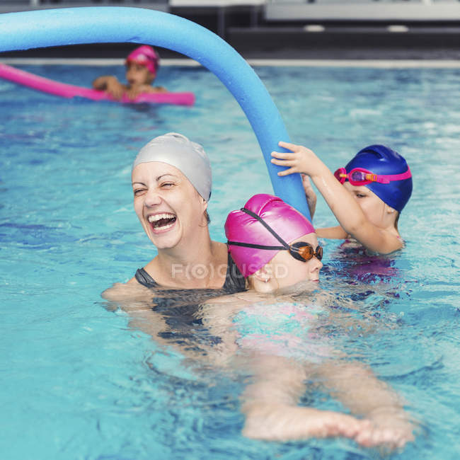 Kinder amüsieren sich mit Lehrerin im Schwimmbad. — Stockfoto