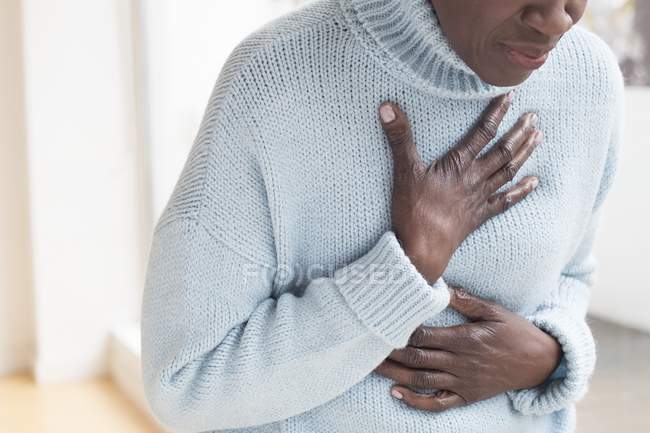 Midsection of mature woman with chest pain. — Stock Photo