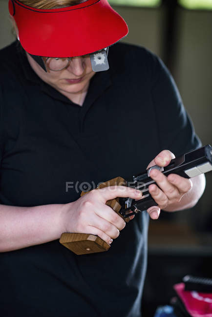 Mulher adulta média se preparando para tiro de pistola esportiva . — Fotografia de Stock