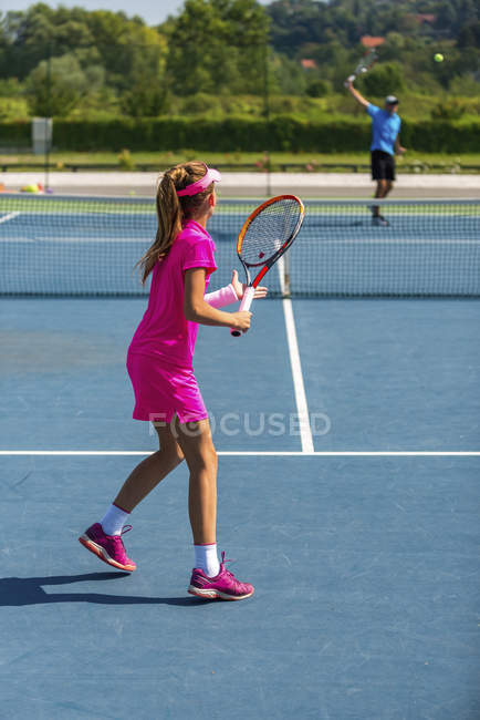 Tennis instructor training adolescent girl in summer. — Stock Photo