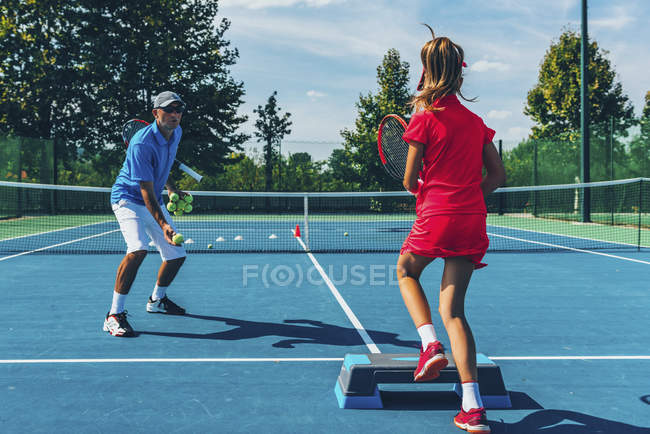Joueur de tennis adolescent pratiquant avec un instructeur masculin en classe de tennis . — Photo de stock