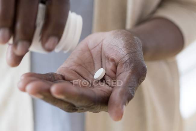 Primer plano de las manos de la mujer madura que toma medicamentos . - foto de stock
