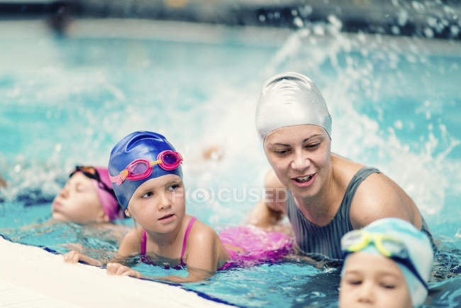 Istruttore di nuoto con bambini in piscina . — Foto stock