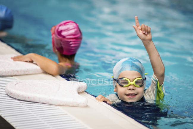 Boy celebrating swimming race win in swimming pool. — Stock Photo