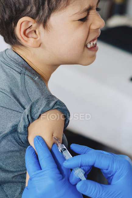 Médico fazendo vacinação seringa para menino pré-escolar na clínica médica . — Fotografia de Stock